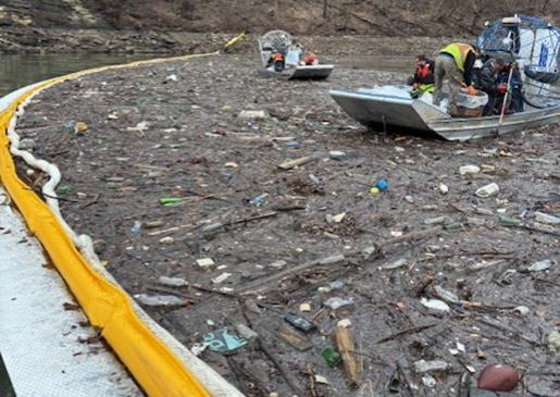 Crews collected sticks and other debris after deploying 5,000 feet of containment boom on R.D. Bailey Lake.
